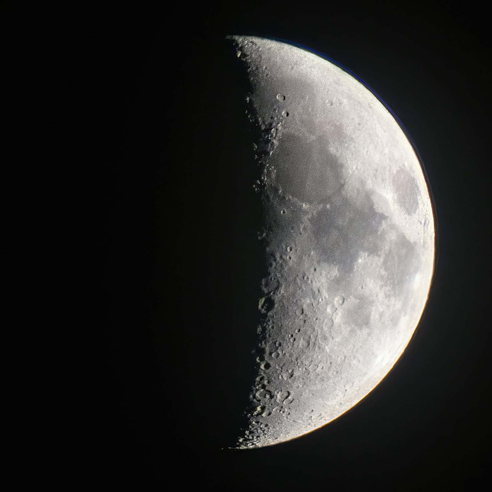 Crisp image of the half moon captured in the night sky, showcasing its craters and texture.